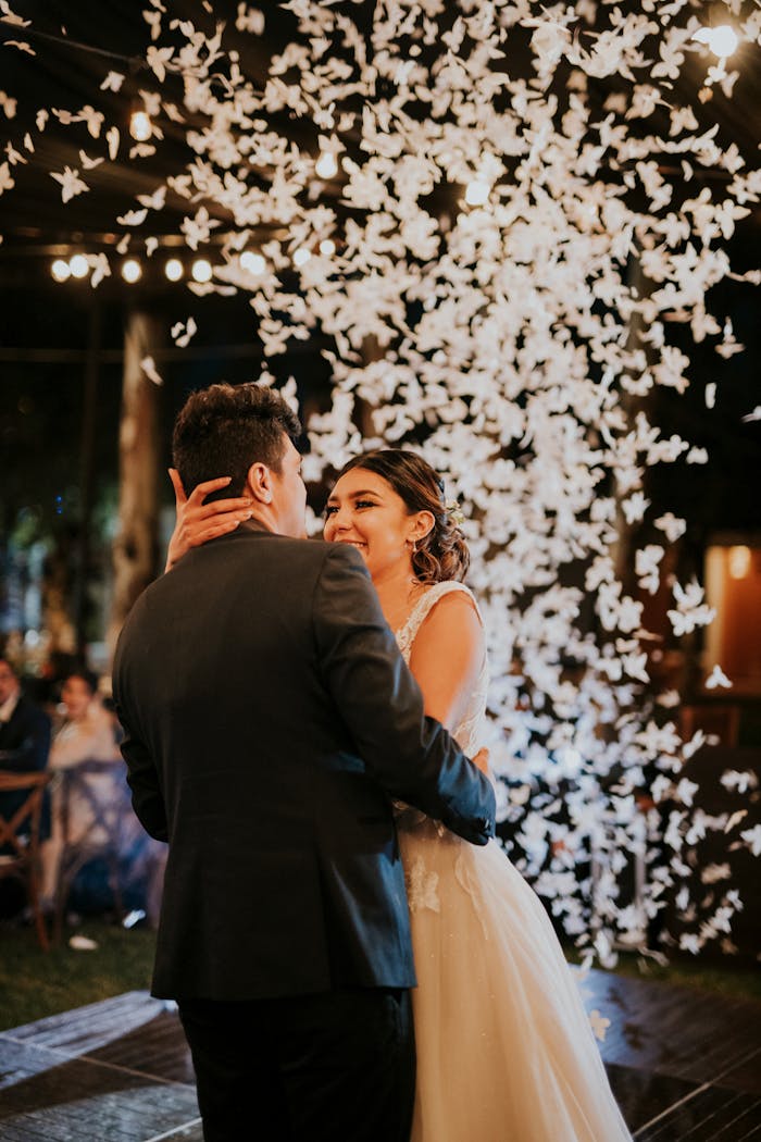 A Newlywed Couple Dancing and Showered with Flower Petals